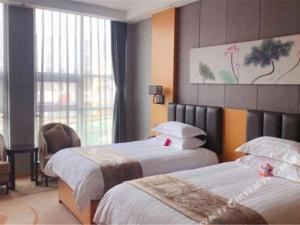 済南市にあるBorrman Hotel Jinan Yijia Exhibition Center Laotun Metro Stationのベッド2台と窓が備わるホテルルームです。