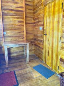 Habitación de madera con banco y puerta en Surf Beach Hotel, en Arugam Bay