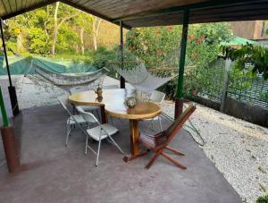un patio con mesa, sillas y hamaca en 5 Private yard, adorable LARGE condo, beautiful pool!, en Carrillo