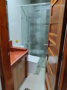 a bathroom with a glass shower and a toilet at Norlu Cedec Midpoint Hotel in Rosario