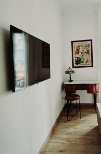 a room with a television on a wall with a table at Jaime III - Palma center - Luxury Suites in Palma de Mallorca