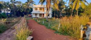una casa con un camino de tierra delante de ella en VIBGYOR HOME AWAY FROM HOME, en Kānnangād