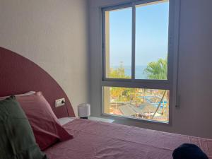 een slaapkamer met een bed en een groot raam bij Ático Alegría Del Mar in Torrox Costa