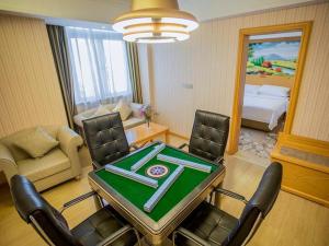 una habitación con mesa y sillas y un dormitorio en Vienna Hotel Shenzhen Henggang Metro Station en Bingkeng