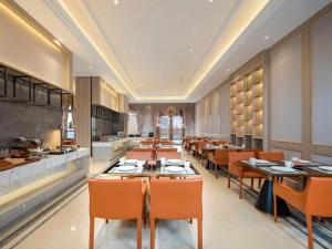 Vienna Hotel Tianjin Binhai New District Ocean High-Tech Zone في Binhai: غرفة طعام كبيرة مع طاولات وكراسي