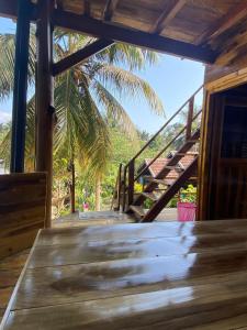 una terraza de madera con escaleras y una palmera en Surf Beach Hotel, en Arugam Bay