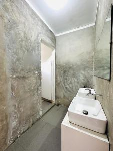 baño con lavabo y pared en Dayon Hostel, en Corón