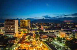 una città illuminata di notte con edifici di RoomQuest Chiang Mai Tha Sala a Chiang Mai Altre 34 foto