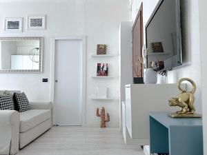 a white living room with a couch and a table at The Boutique Houses Milan - Navigli in Milan