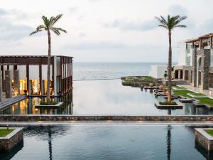 a rendering of a resort swimming pool with the ocean in the background at Amirandes Grecotel Boutique Resort in Gouves