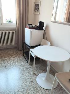 Habitación con mesa blanca, sillas y microondas. en Private room and bathroom close to Piazzale Roma in Venice Mestre en Mestre