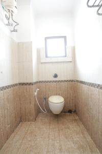 a bathroom with a toilet and a window at Goroomgo Hotel Hi5 Stay Near Care Hospital in Bhubaneshwar