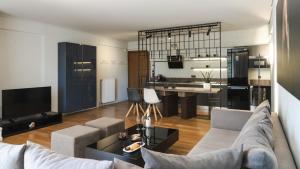 ein Wohnzimmer mit einem Sofa und einem Tisch in der Unterkunft Elliniko Luxury Residence in Athen