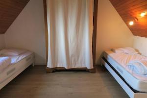 two twin beds in a room with a canopy at Maison bretonne exposée Sud avec jardin à 50m de la baie Ste Anne à TREGASTEL - Réf 44 in Trégastel