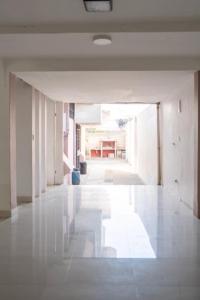 un couloir d'un immeuble avec un sol blanc dans l'établissement Tourist house 1, à Otavalo