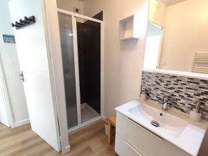 un bagno con lavandino e specchio di Appartement avec WIFI, terrasse, jardin à TREBEURDEN Réf - 678 a Trébeurden