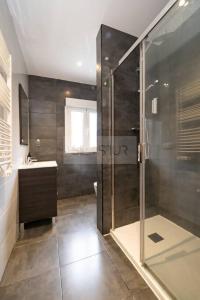 Vive Oviedo II Apartamento في أوفِييذو: حمام مع دش ومغسلة