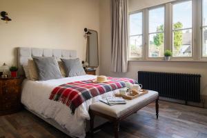 a bedroom with a bed with a blanket and a table at Grange Cottage in Bursledon
