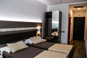 a hotel room with two beds and a mirror at Mediterranea Hotel & Convention Center in Salerno