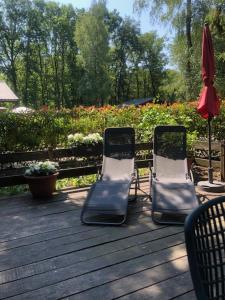祖騰達爾的住宿－Chalet Luxe，木甲板上配有两把草坪椅和一把遮阳伞