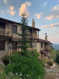 an old stone building with a tree in front of it at Nymfes Guesthouse in Synikia Mesi Trikalon