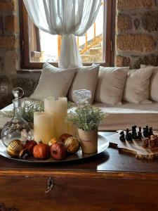 una mesa con un tablero de ajedrez y velas y un sofá en Nymfes Guesthouse, en Synikia Mesi Trikalon