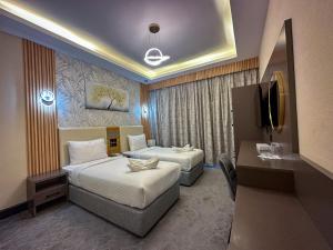 杜拜的住宿－GOLD SKY AVENUE HOTEL，酒店客房设有两张床和电视。