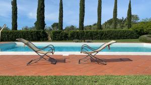 two chairs sitting next to a swimming pool at Ghiaccio Bosco in Capalbio