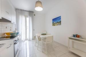 een witte keuken met een witte tafel en stoelen bij Trilocale Corso Italia 24 piano terra con spazio esterno in Gallipoli