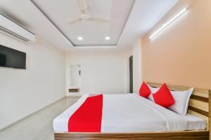 a bedroom with a bed with red pillows at OYO Flagship 61373 Hotel Paradise in Chittaurgarh