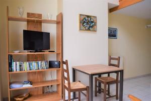 Una televisión o centro de entretenimiento en Appartement avec terrasse VUE SUR MER plage du Coz-Pors à TREGASTEL - Réf 726