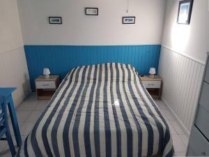 een bed in een kleine kamer met 2 nachtkastjes bij Petite maison de plain-pied à 150m de la mer à TREGASTEL - Réf 78 in Trégastel