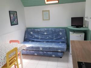 een woonkamer met een blauwe bank en een tafel bij Petite maison de plain-pied à 150m de la mer à TREGASTEL - Réf 78 in Trégastel