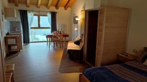 Pokój z łóżkiem i salonem ze stołem w obiekcie Ai Monti w mieście Barcis
