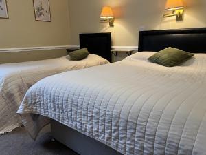 two beds sitting next to each other in a bedroom at Royal Oak Hotel, Garstang in Garstang