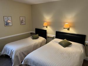 two beds in a room with white sheets and green pillows at Royal Oak Hotel, Garstang in Garstang