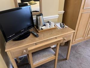 uma televisão sentada numa mesa de madeira com uma televisão em Royal Oak Hotel, Garstang em Garstang