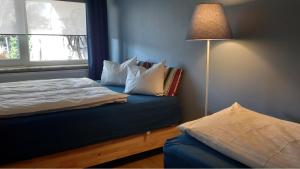 een slaapkamer met een bed met kussens en een lamp bij De Villo in Hasselt