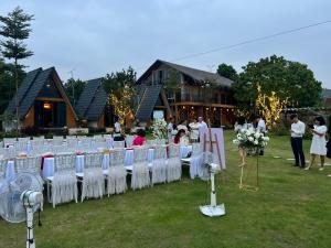 eine Reihe von Tischen mit weißen Stühlen vor einem Gebäude in der Unterkunft Moc Villa - Venuestay in Hanoi