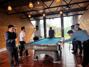 a group of people standing around a pool table at Moc Villa - Venuestay in Hanoi