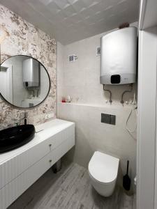 bagno bianco con servizi igienici e specchio di PaVoni Veranda a Łeba
