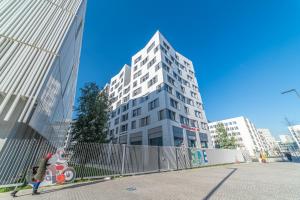 un grand bâtiment blanc avec un scooter devant lui dans l'établissement Break and Home Campus Condorcet Maison des chercheurs, à Aubervilliers