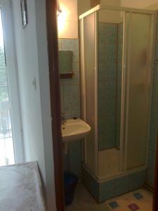 La salle de bains est pourvue d'une douche et d'un lavabo. dans l'établissement Maxim Pokoje Gościnne, à Iwonicz-Zdrój