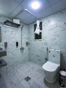 杜拜的住宿－GOLD SKY AVENUE HOTEL，白色的浴室设有卫生间和窗户。