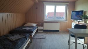 um quarto com 2 camas, uma secretária e uma televisão em Ferienhaus „Zum alten Fröhlich“ em Dresden