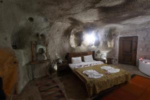 a bedroom with a bed and a tub in a cave at Cappadocia Snora Cave in Nevsehir