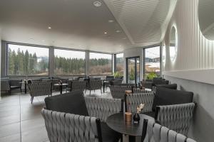 a restaurant with chairs and tables and windows at SAVOIE Apartments Bukovel in Bukovel