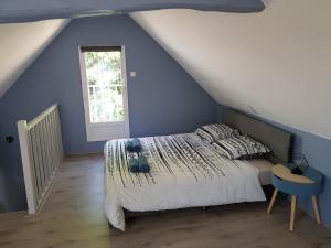 ein Schlafzimmer mit einem Bett und einer blauen Wand in der Unterkunft La récréation Lochoise in Loches