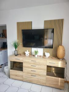 a wooden entertainment center with a flat screen tv on top at Ferienhaus Kranichnest in Barth