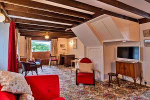 Finest Retreats - Lewcott في سنن: غرفة معيشة بها أريكة حمراء وتلفزيون